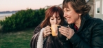 Women sitting next to each other drinking coffee