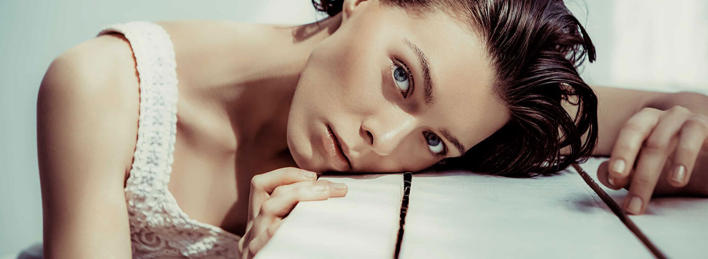 Model laying her head down on a table